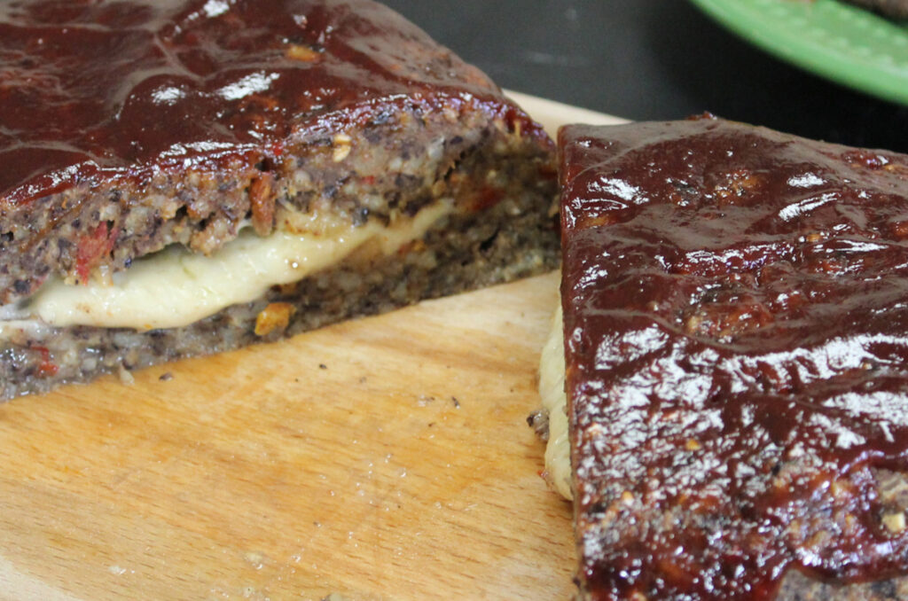 Stuffed meatloaf made from black bean burger survival food recipe sitting on a wooden cutting board