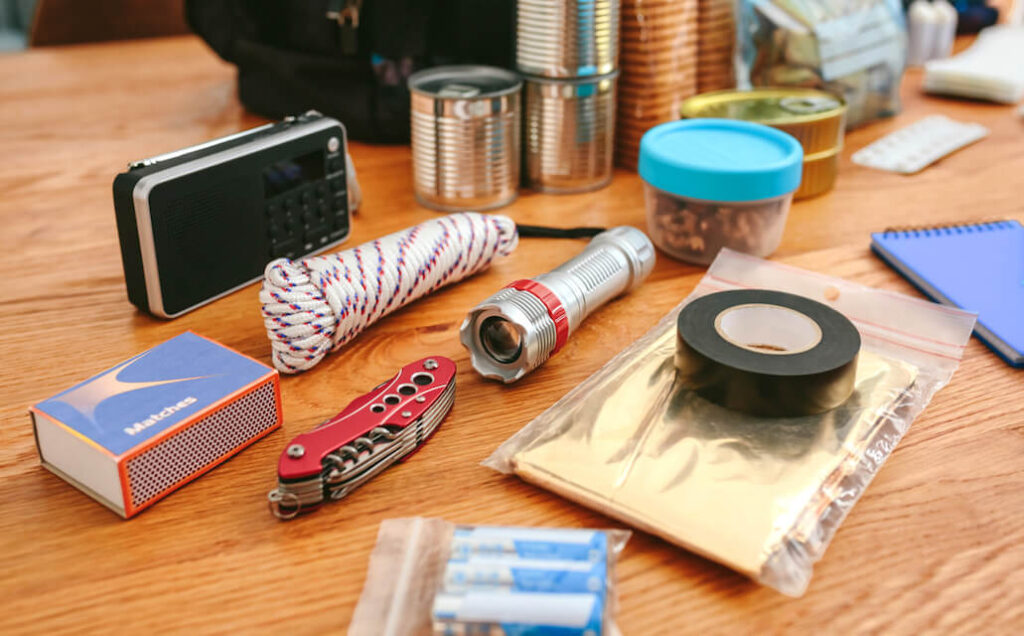 survival items for an emergency kit spread out on table