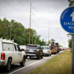 line of vehicles following evacuation route during a hurricane