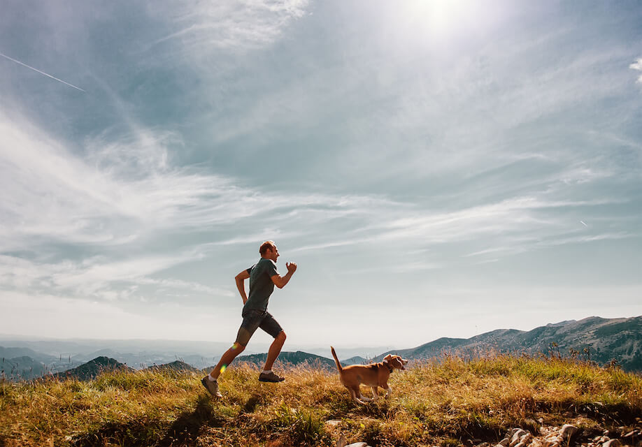 man on a run with his dog to prepare for survival fitness
